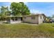 Exterior view of a home with a screened-in patio and an expansive grass backyard at 941 Grey Oak Ct, Orlando, FL 32809