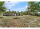 The backyard shows grass, a utility connection, a screened-in porch, and trees at 941 Grey Oak Ct, Orlando, FL 32809