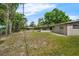 The backyard offers a large space with grass, trees, and a screened-in patio attached to the house at 941 Grey Oak Ct, Orlando, FL 32809