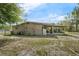 The exterior shows the backyard, including a screened-in porch, grass, and side street at 941 Grey Oak Ct, Orlando, FL 32809