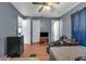 Cozy bedroom with wood-look floors, ceiling fan, and blue-painted walls, offering a relaxing space at 941 Grey Oak Ct, Orlando, FL 32809