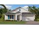 Charming single-Gathering home featuring light gray facade, blue shutters and manicured lawn at 101 Kayak Ave, Haines City, FL 33844