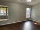 Spacious bedroom featuring hardwood floors, a ceiling fan, and two windows with natural light at 12546 Britwell Ct, Orlando, FL 32837