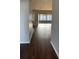 Hallway with hardwood floors that lead to a sunroom with sliding glass doors offering plentiful light at 12546 Britwell Ct, Orlando, FL 32837