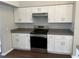 Modern kitchen with white cabinetry, stainless steel appliances and gray countertops at 12546 Britwell Ct, Orlando, FL 32837