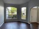 Bright living room showcasing rich hardwood flooring, neutral gray walls, and double windows with views of lush landscaping at 12546 Britwell Ct, Orlando, FL 32837