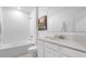 Bright, white bathroom featuring a shower-tub combo, granite countertop, and modern fixtures at 128 Adventure Ave, Davenport, FL 33837