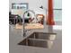 Close-up of the kitchen island with stainless steel sink, faucet and ample quartz countertop space at 128 Adventure Ave, Davenport, FL 33837