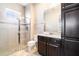 Modern bathroom featuring a walk-in shower with glass door, dark wood cabinets, and a white countertop at 12849 Bovet Ave, Orlando, FL 32827