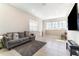 Bright living room featuring a comfortable gray sofa, tile flooring, and plenty of natural light at 12849 Bovet Ave, Orlando, FL 32827