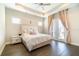 Bright main bedroom featuring french doors, tray ceilings and hardwood floors at 12849 Bovet Ave, Orlando, FL 32827