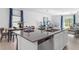 Stylish kitchen island with stainless steel sink and dishwasher overlooks dining and living areas at 132 Adventure Ave, Davenport, FL 33837