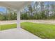 Relaxing view of backyard featuring green grass and trees from covered porch at 13457 Sw 53Rd St, Ocala, FL 34481