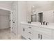 Bright bathroom featuring double sinks, white cabinetry, and a large mirror at 13457 Sw 53Rd St, Ocala, FL 34481
