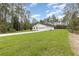 Expansive front yard view of a one-story home with an attached two-car garage and a pristine driveway at 13457 Sw 53Rd St, Ocala, FL 34481