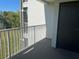 Balcony with white railing overlooking green space near a black storage door at 13929 Fairway Island Dr # 822, Orlando, FL 32837