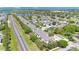 Wide aerial shot of a townhome community near a lake and a busy street at 1613 Priory Cir, Winter Garden, FL 34787