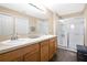 Bathroom featuring double sinks, a vanity, and a glass-enclosed shower for a modern aesthetic at 1613 Priory Cir, Winter Garden, FL 34787