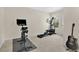 Bright bedroom featuring home gym with exercise bike, elliptical machine, and acoustic guitar at 1613 Priory Cir, Winter Garden, FL 34787