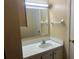 Bathroom featuring a cream colored sink and mirror with a towel rack above the toilet at 220 N Idlewood Ave # 203, Bartow, FL 33830