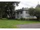 Gray two-story building with mature trees, satellite dishes, and green lawn at 220 N Idlewood Ave # 203, Bartow, FL 33830