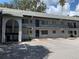 Two story condo building with parking spaces and mature landscaping on a sunny day at 220 N Idlewood Ave # 203, Bartow, FL 33830