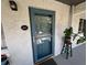 Charming condo front door with textured wall, plants, and a stylish blue screen door at 220 N Idlewood Ave # 203, Bartow, FL 33830