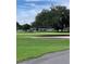 Golf course featuring rolling green hills, a sand trap, and a clubhouse in the background at 220 N Idlewood Ave # 203, Bartow, FL 33830
