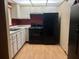 Compact kitchen featuring white cabinets, black appliances, and laminate countertops at 220 N Idlewood Ave # 203, Bartow, FL 33830