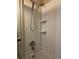 A clean tiled shower features a detachable shower head, silver faucet, and built-in shelving at 220 N Idlewood Ave # 203, Bartow, FL 33830