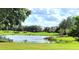 Picturesque pond view on the golf course with lush green grass and clear blue skies at 225 Vestrella Dr, Kissimmee, FL 34759