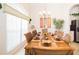 Bright dining room with a long table set for a meal, complemented by large windows and tasteful decor at 252 Julliard Blvd, Davenport, FL 33897