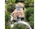 Aerial shot of a home showcasing the tile roof, screened pool enclosure, circular driveway, and wooded surroundings at 257 New Gate Loop, Lake Mary, FL 32746