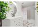 Bright bathroom with modern vanity, round mirror, and tub-shower combination, accented with greenery at 257 New Gate Loop, Lake Mary, FL 32746