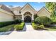 Stately home exterior featuring a grand arched entrance, manicured landscaping, and a tile roof at 257 New Gate Loop, Lake Mary, FL 32746