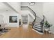 Bright foyer with a winding staircase, modern chandelier, light wood floors, and decorative fish tank feature at 257 New Gate Loop, Lake Mary, FL 32746