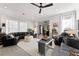 Open concept living room with hardwood floors, a black leather sofa, and plenty of natural light at 257 New Gate Loop, Lake Mary, FL 32746