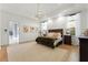 This spacious main bedroom features a modern chandelier, light hardwood floors, and plenty of natural light at 257 New Gate Loop, Lake Mary, FL 32746