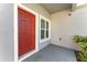 Inviting front entrance with a red door, window, and security camera at 2956 Whispering Trails Dr, Winter Haven, FL 33884