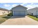 Home exterior view displaying a spacious two-car garage and a driveway at 2956 Whispering Trails Dr, Winter Haven, FL 33884