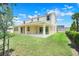 Expansive backyard featuring a covered patio, lush green lawn, and privacy landscaping at 3036 Country Side Dr, Apopka, FL 32712