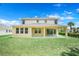 Expansive backyard featuring a covered patio, lush green lawn, and ample space for outdoor activities at 3036 Country Side Dr, Apopka, FL 32712