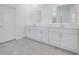 Bright bathroom showcasing double vanity with white cabinets, stone countertops, and tile floors at 3036 Country Side Dr, Apopka, FL 32712