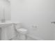 Bathroom featuring a white toilet and pedestal sink, creating a clean and simple space at 3036 Country Side Dr, Apopka, FL 32712
