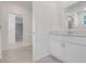 Bright bathroom featuring a white vanity, large mirror and neutral tile flooring at 3036 Country Side Dr, Apopka, FL 32712