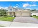 Charming two-story home with manicured lawn, brick driveway, and a spacious three-car garage at 3036 Country Side Dr, Apopka, FL 32712