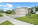Inviting home with a brick driveway leading to a two-car garage, lush lawn and shrubbery at 3036 Country Side Dr, Apopka, FL 32712