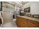 Well-lit bathroom features tiled shower with glass door, granite countertops and wood cabinets at 401 Timberwalk Ln, Lake Mary, FL 32746