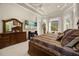 Well-lit bedroom with a decorative tray ceiling, a large window nook, and a beach scene on the television at 401 Timberwalk Ln, Lake Mary, FL 32746