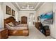 Large primary bedroom with a coffered ceiling, decorative art, a television, and hallway access at 401 Timberwalk Ln, Lake Mary, FL 32746